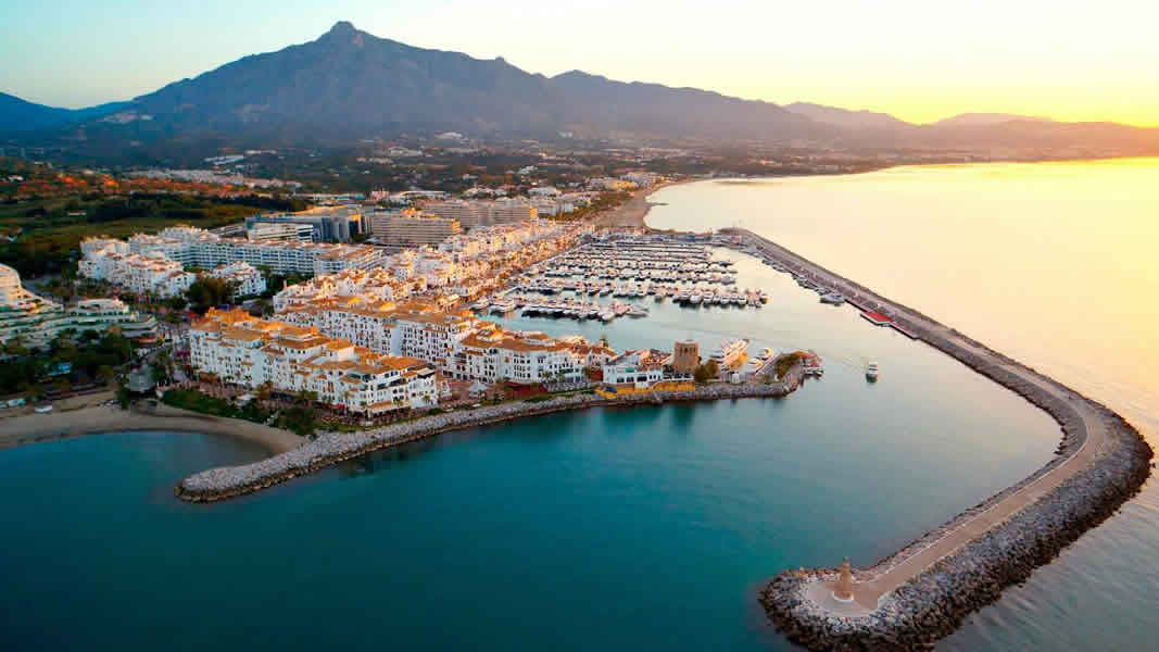 Aerial view of Puerto Banús on the Costa del Sol during sunrise, where there are many luxury properties for sale and rent